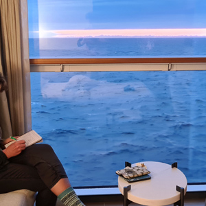 2023-09-15 - Carin is de reisaantekeningen aan het bijwerken in onze hut<br/>Op zee - Tussen Reykjavik en oost-Groenla - IJsland<br/>SM-G981B - 5.4 mm - f/1.8, 1/35 sec, ISO 800